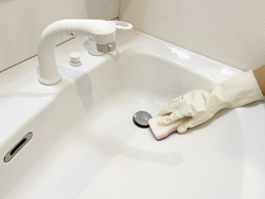 スポンジで洗面台排水口ふきんを掃除する様子