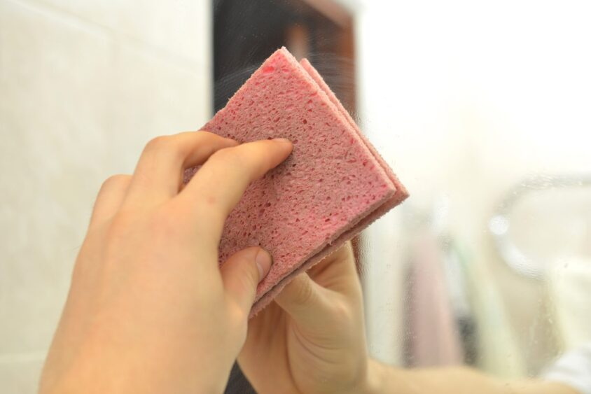 鏡をスポンジでみがく様子