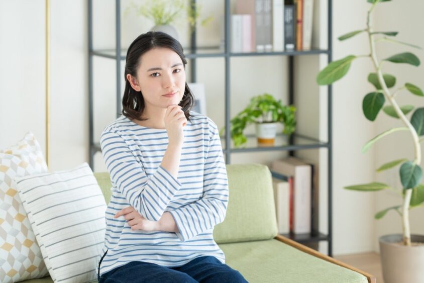 首をかしげる若い女性