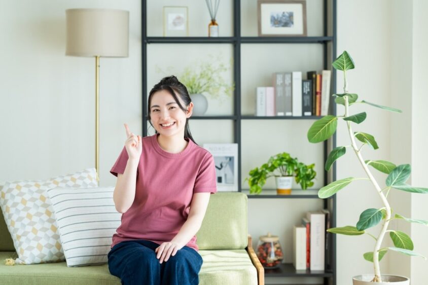 人差し指を立てている笑顔の女性