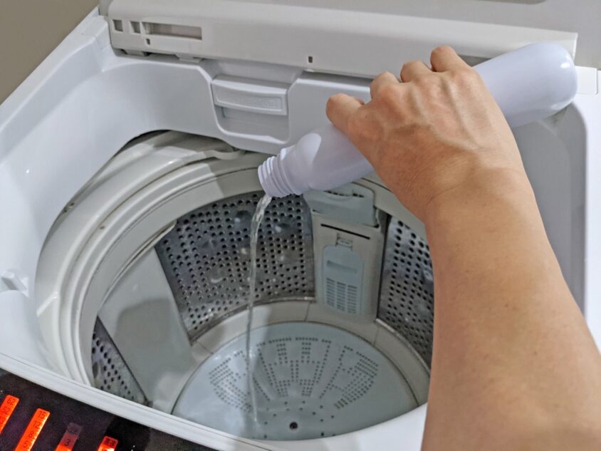 洗濯機に洗浄剤を注ぐ様子