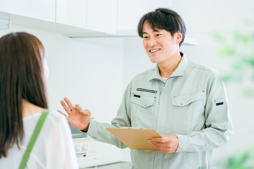 若い女性に説明してる男性業者